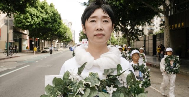 <b>Mourning Ms. Wang Yifei</b> holds a wreath to mourn her sister who was killed in a Chinese labor camp because she stood up for her faith in Falun Gong. Ms. Wang fled China to escape the same fate, and is shown here in a march in Los Angeles in 2016.